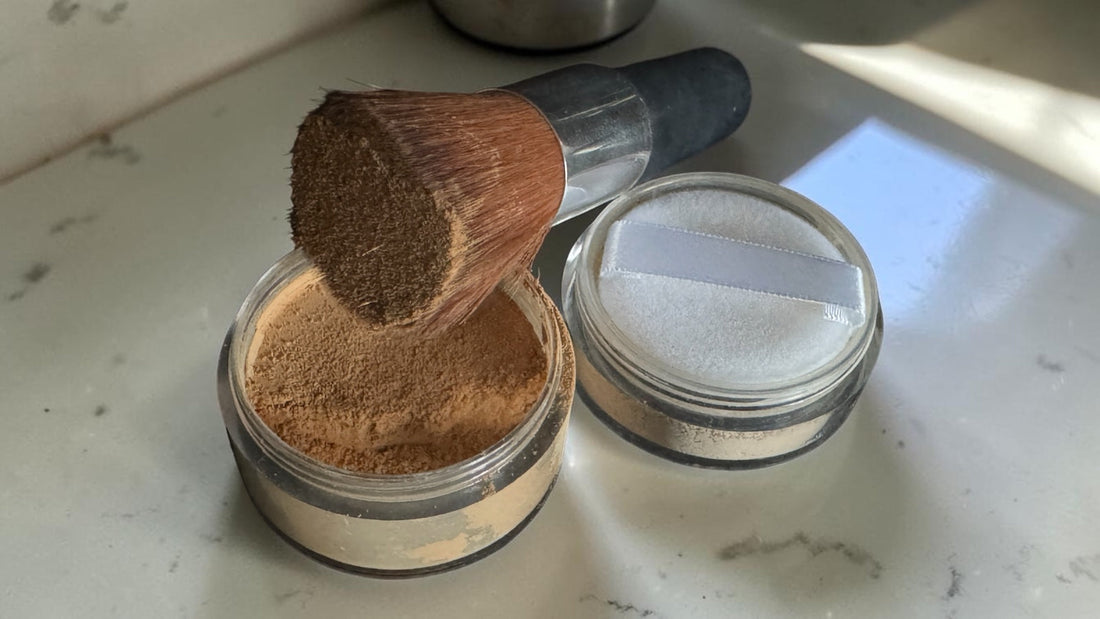 Open jar of mineral foundation beside a finishing powder with powder puff, illustrating whether a finishing or setting powder is needed over mineral foundation